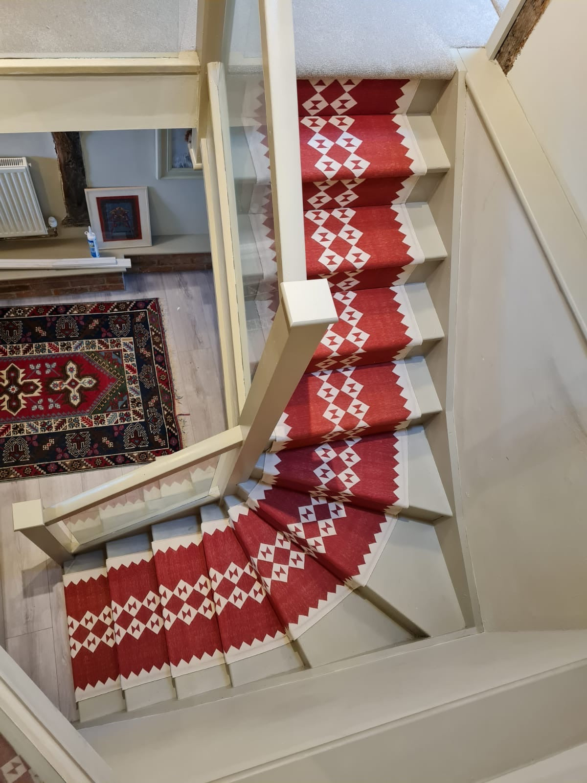 Eye duo red raw stair runner by Sophie Cooney Runners on a winding staircase in a beautiful London home